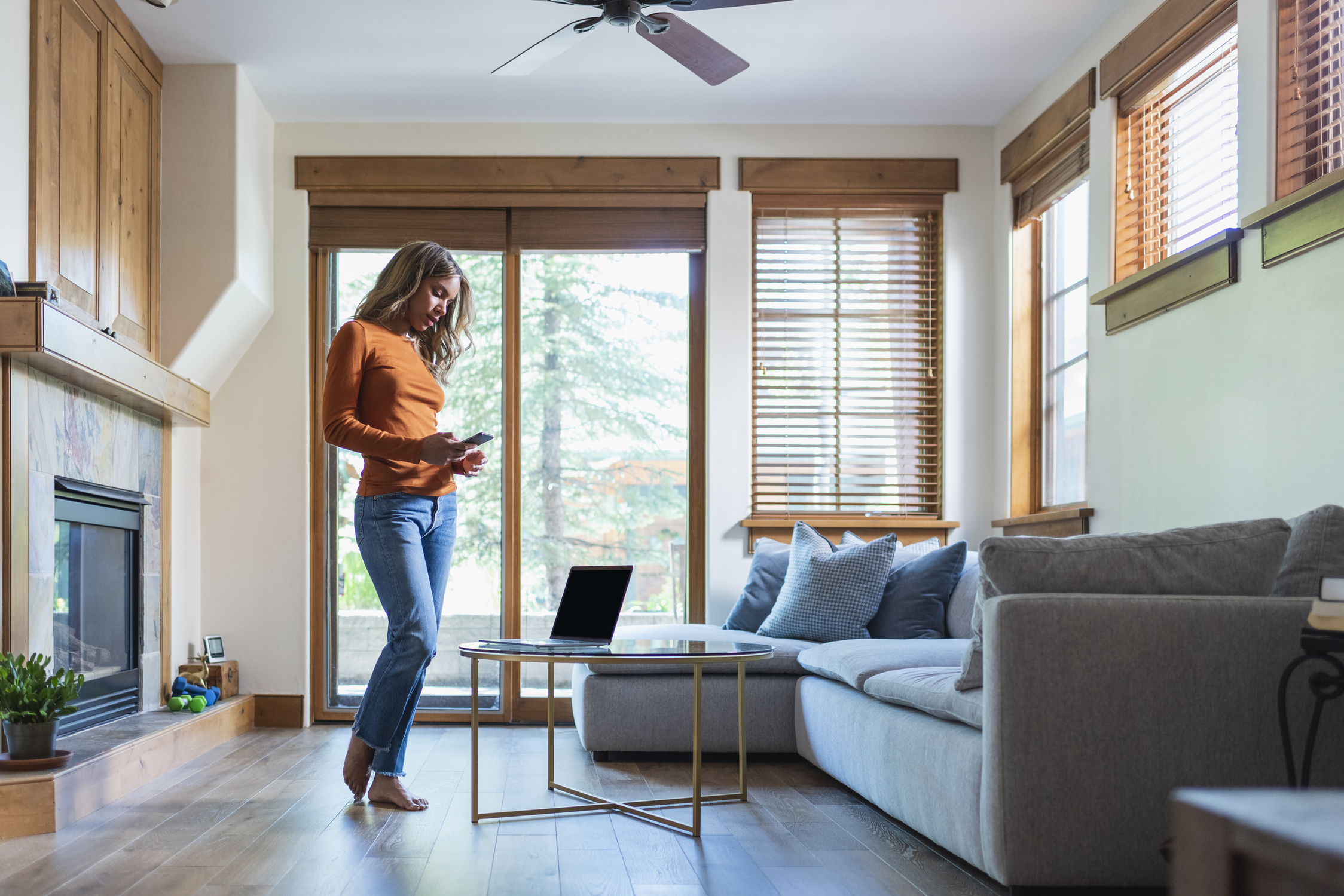 a woman on her phone shopping online at Dick Stark Carpet One for flooring.